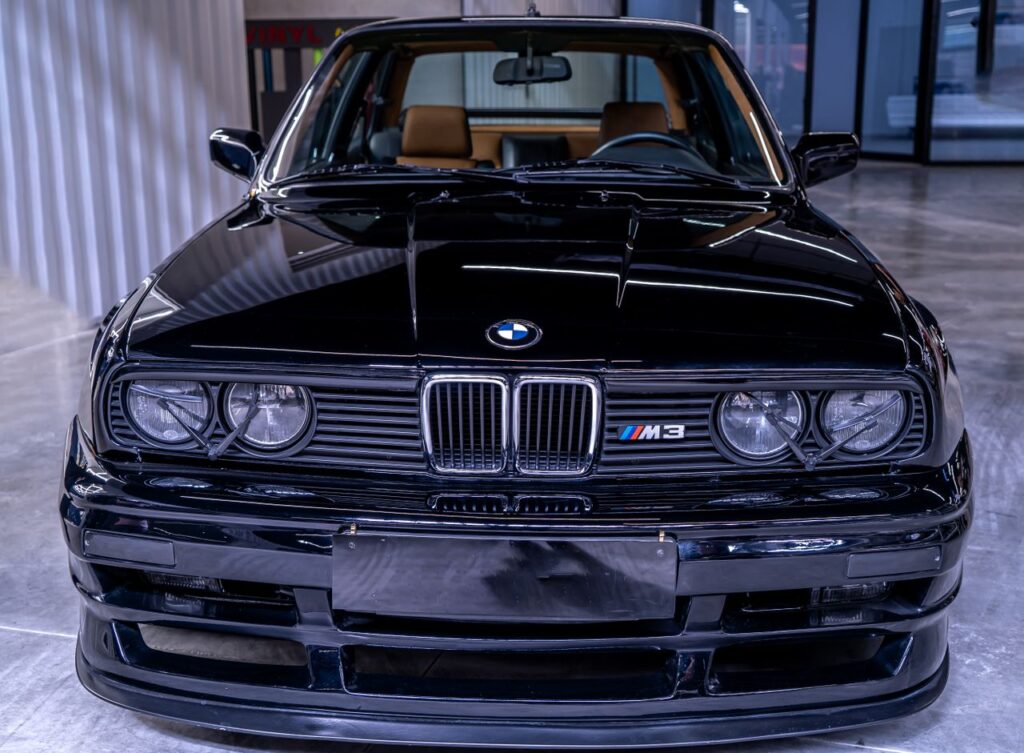 Gallerie Front view of a classic BMW E30 M3, showcasing its iconic design and vintage style.